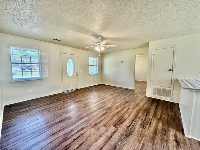 foyer entrance featuring ceiling fan, dark wood finished floors, and visible vents
