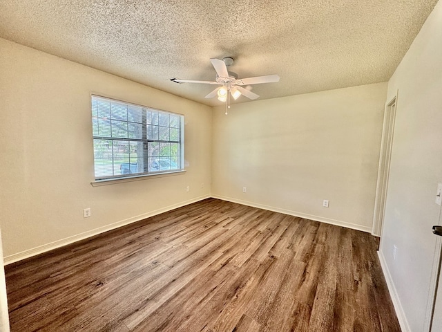 empty room with baseboards, ceiling fan, dark wood-style floors, and a textured ceiling