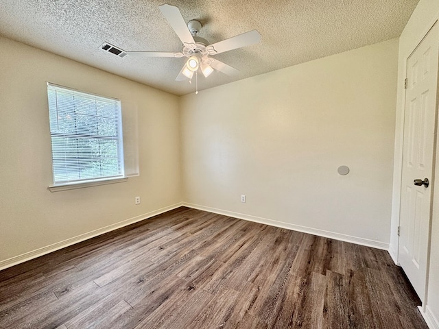 unfurnished room with a textured ceiling, ceiling fan, visible vents, and dark wood-style floors