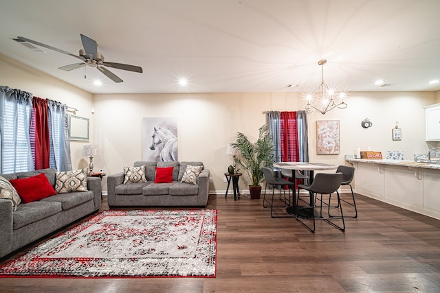 living area with recessed lighting, baseboards, visible vents, dark wood-style flooring, and ceiling fan with notable chandelier