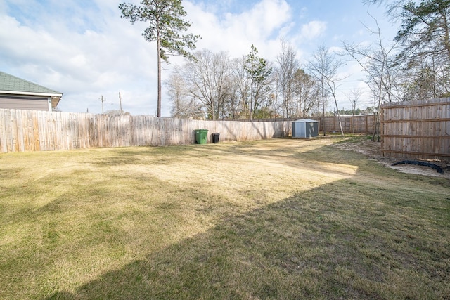 view of yard featuring a fenced backyard, an outdoor structure, and a storage unit