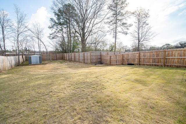 view of yard with an outbuilding, a fenced backyard, and a shed