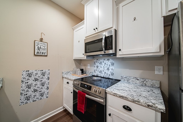 kitchen featuring stainless steel appliances, white cabinetry, baseboards, and light stone countertops