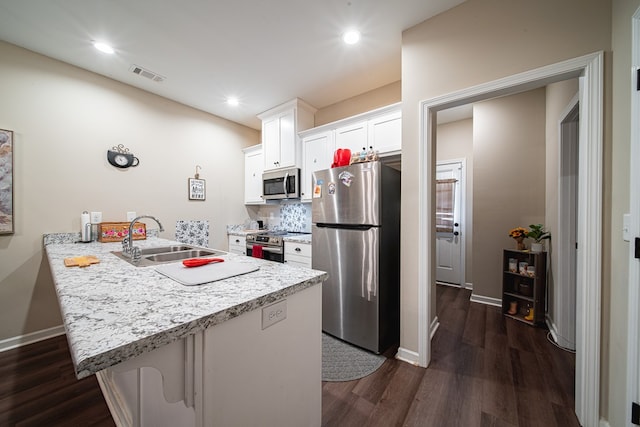 kitchen with visible vents, appliances with stainless steel finishes, dark wood-style flooring, a peninsula, and a sink