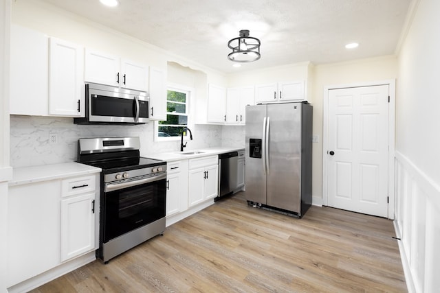 2917 Doyle Ave, Columbus, GA 31907 - kitchen with appliances with stainless steel finishes, a sink, light countertops, white cabinetry, and ornamental molding