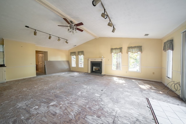 unfurnished living room featuring vaulted ceiling with beams, ceiling fan, and a textured ceiling