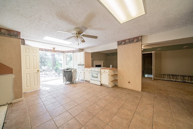 unfurnished living room featuring ceiling fan, light tile patterned floors, and a textured ceiling