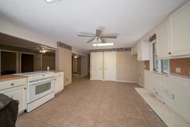 kitchen with electric range, light tile patterned floors, white cabinets, and a textured ceiling