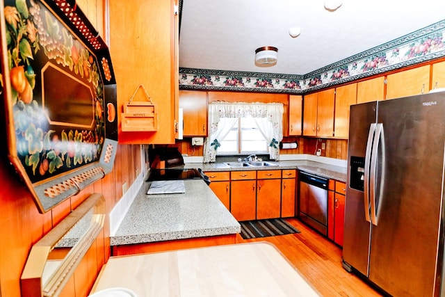 kitchen with sink, stainless steel appliances, and light hardwood / wood-style floors