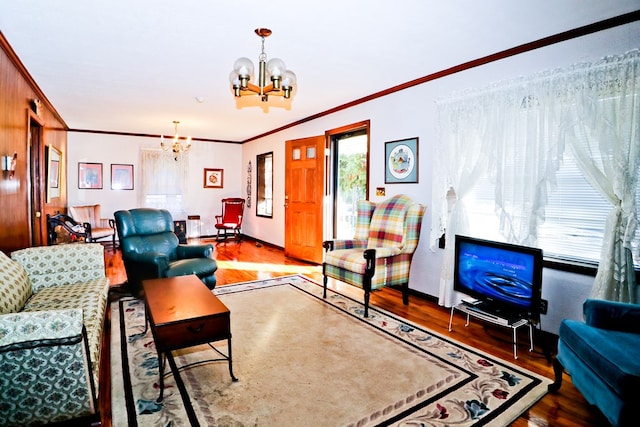 living room with a notable chandelier, ornamental molding, and hardwood / wood-style floors