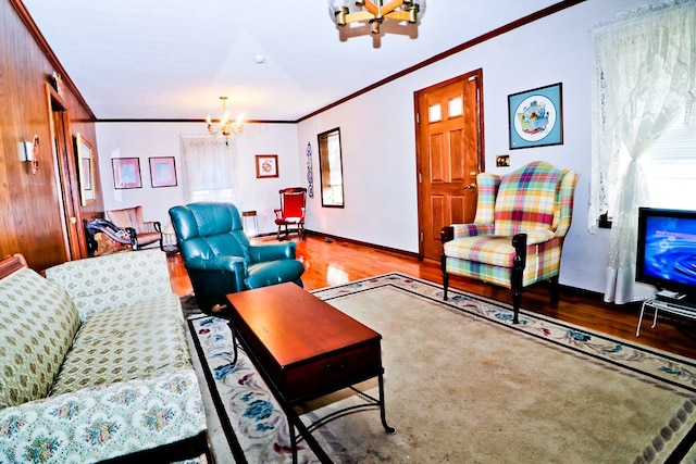 living room featuring a notable chandelier, ornamental molding, and light hardwood / wood-style floors