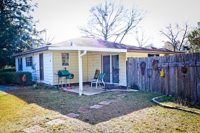 rear view of house featuring a yard and a patio area