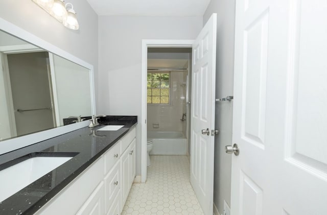 full bath with a sink, toilet, double vanity, and tile patterned flooring