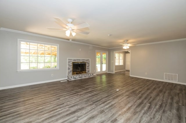 unfurnished living room featuring a wealth of natural light, visible vents, a fireplace, and a ceiling fan