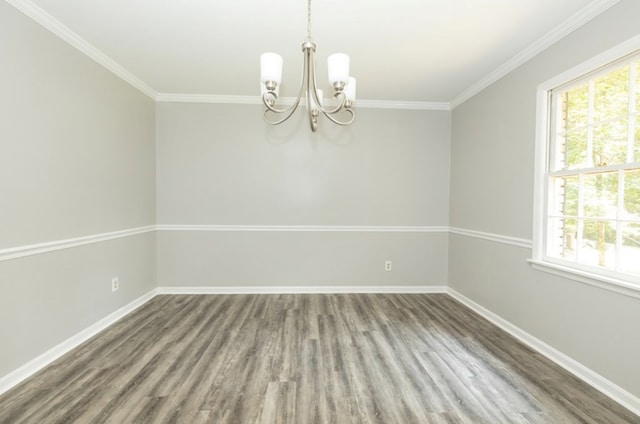 unfurnished room with wood finished floors, a healthy amount of sunlight, and a chandelier