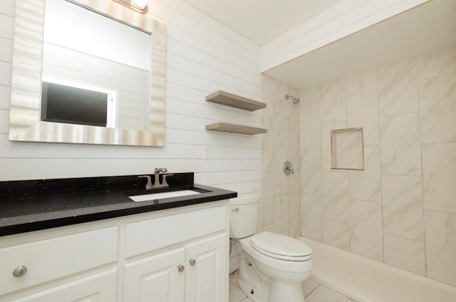 full bathroom with vanity, toilet, and tiled shower