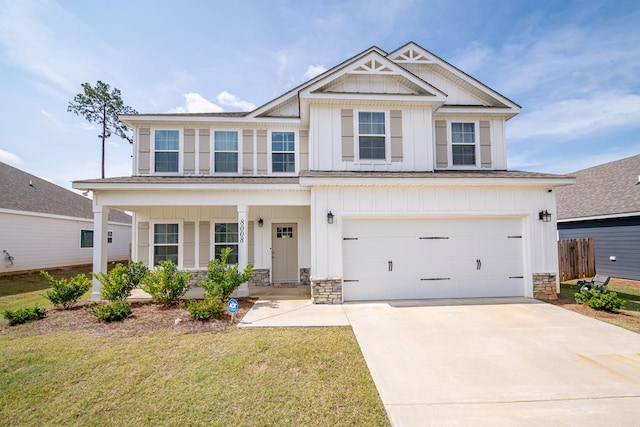 8008 Barton Dr, Midland, GA 31820 - view of front of home featuring board and batten siding, concrete driveway, an attached garage, a front yard, and stone siding