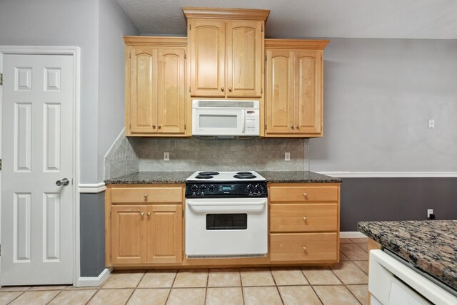 kitchen featuring white appliances, light brown cabinetry, decorative backsplash, light tile patterned flooring, and baseboards
