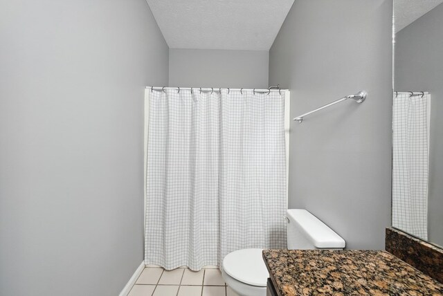 bathroom featuring toilet, tile patterned flooring, vanity, a textured ceiling, and a shower with curtain