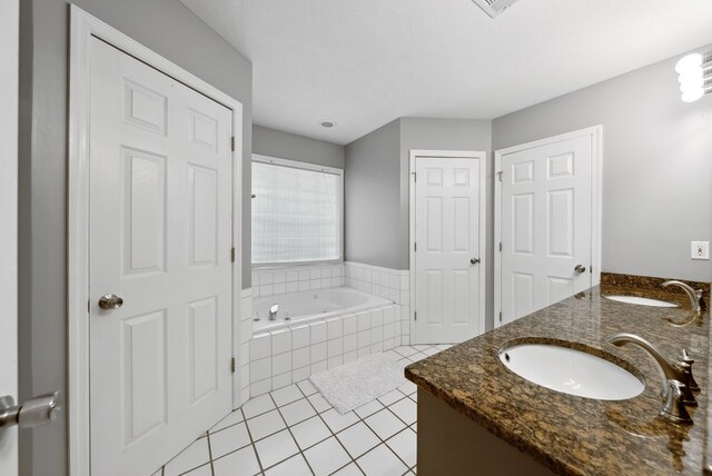 full bathroom featuring tile patterned flooring, a bath, and double vanity