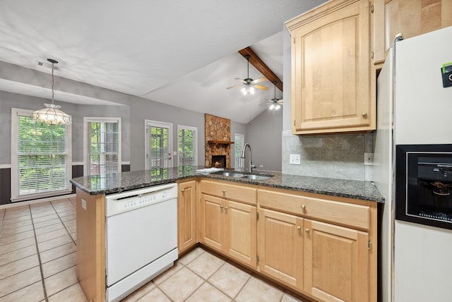 kitchen featuring white appliances, a sink, light tile patterned floors, light brown cabinetry, and a peninsula