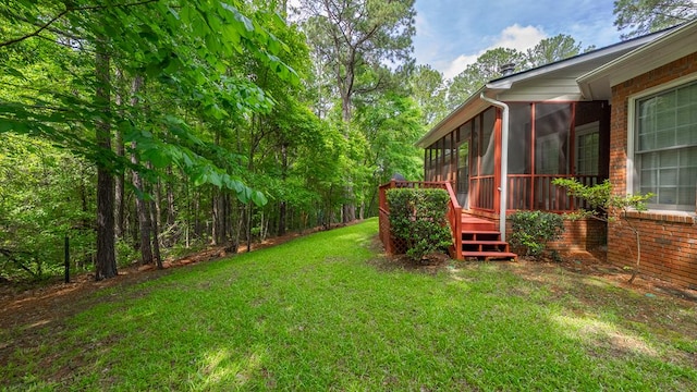 view of grassy yard with a sunroom