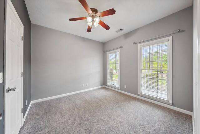 empty room with baseboards, carpet floors, and a ceiling fan