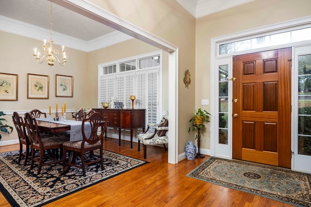 dining space with crown molding, hardwood / wood-style floors, and a chandelier