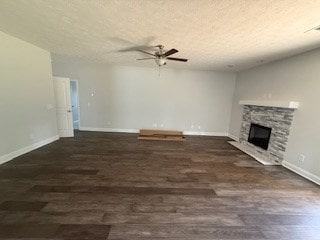 7300 Pine Chase Dr, Midland, GA 31820 - unfurnished living room featuring a fireplace, wood finished floors, a ceiling fan, and a textured ceiling