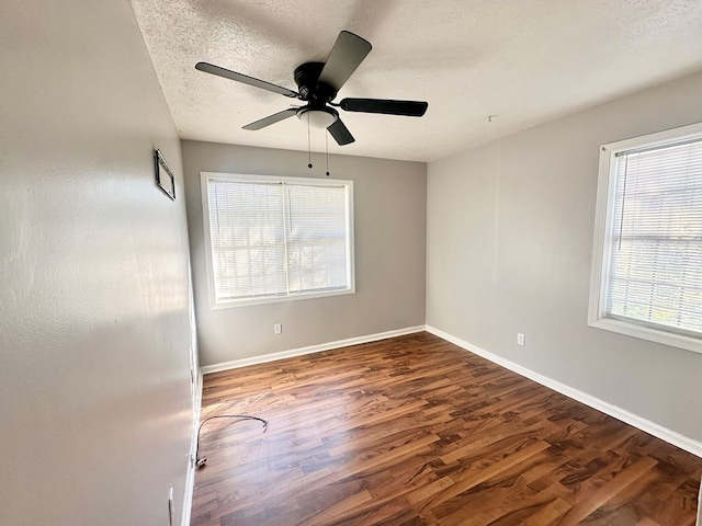 unfurnished room with ceiling fan, dark hardwood / wood-style flooring, and a textured ceiling