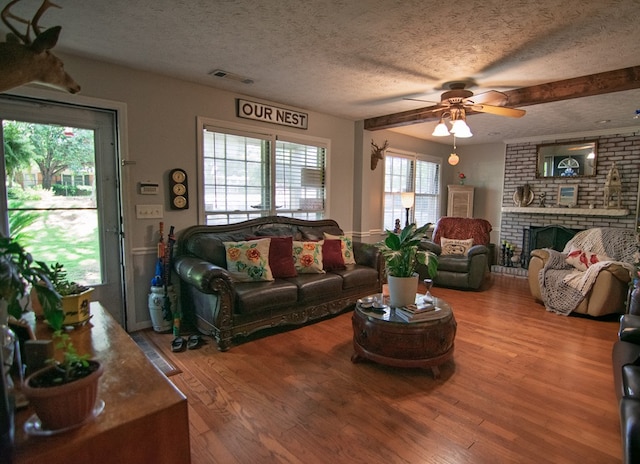 5063 3rd Ave, Columbus, GA 31904 - living area featuring a textured ceiling, a ceiling fan, wood finished floors, and a fireplace
