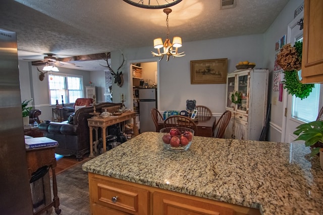 5063 3rd Ave, Columbus, GA 31904 - kitchen featuring freestanding refrigerator, a textured ceiling, a ceiling fan, a chandelier, and dark wood-type flooring