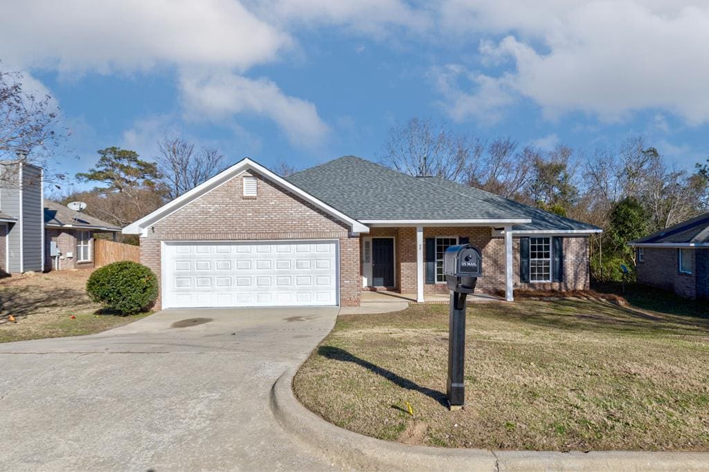 ranch-style home with a garage and a front lawn