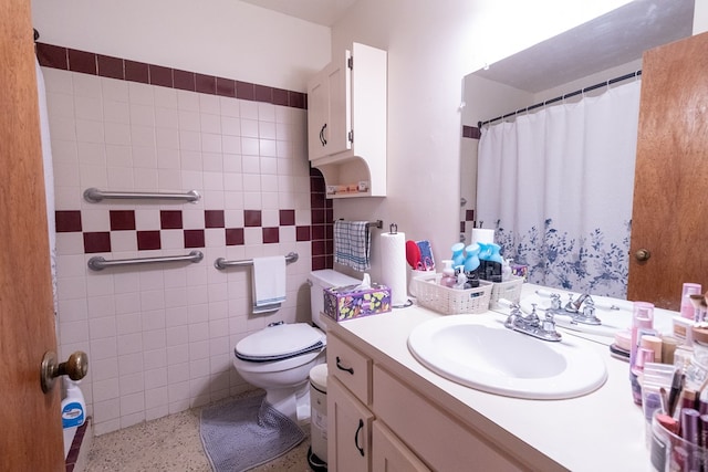 bathroom featuring toilet, a shower with curtain, speckled floor, vanity, and tile walls