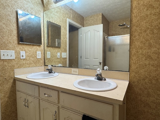 bathroom featuring vanity, a shower with shower door, a textured ceiling, and a skylight