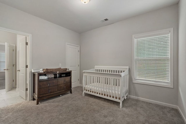 carpeted bedroom featuring a crib