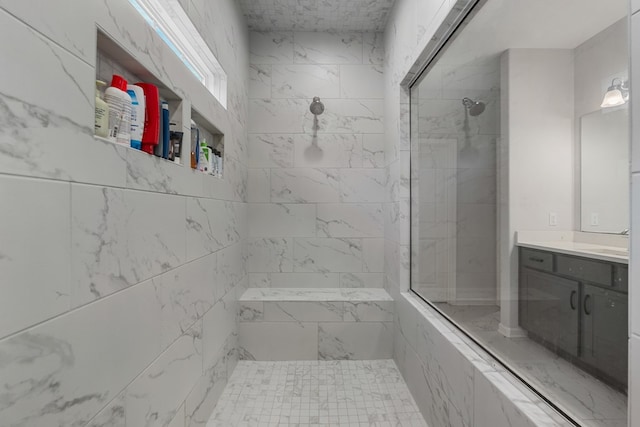 bathroom featuring vanity and tiled shower