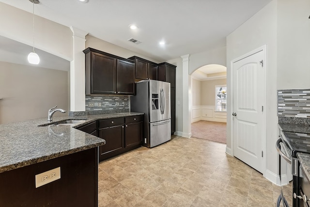 kitchen with pendant lighting, sink, dark stone countertops, dark brown cabinetry, and stainless steel appliances