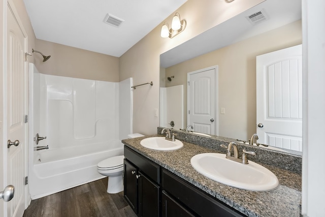 full bathroom featuring vanity, hardwood / wood-style floors, shower / washtub combination, and toilet