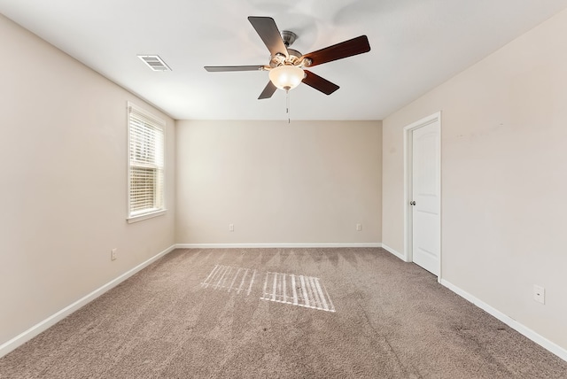 spare room with ceiling fan and carpet