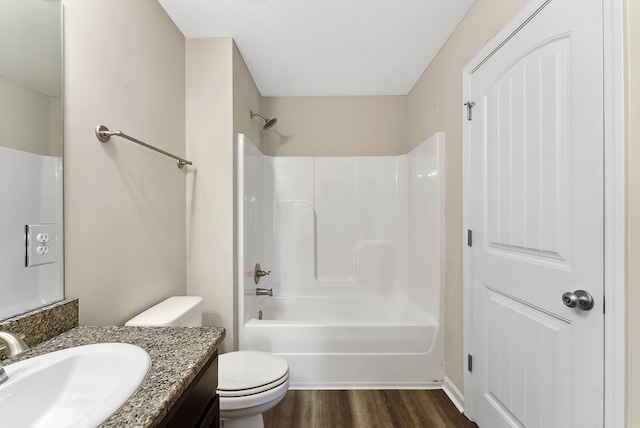 full bathroom featuring vanity, hardwood / wood-style floors, washtub / shower combination, and toilet