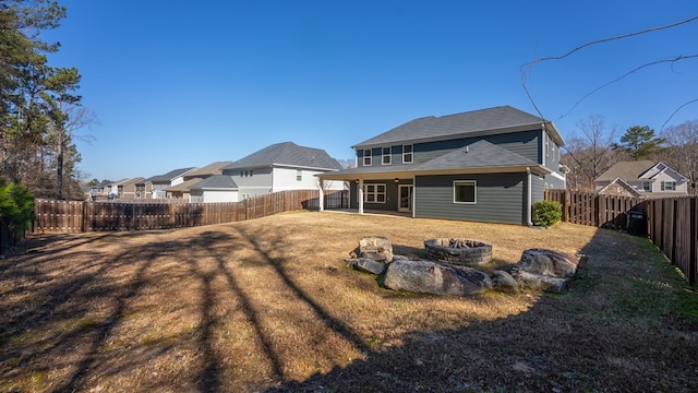 back of property featuring a fire pit, a patio area, and a lawn