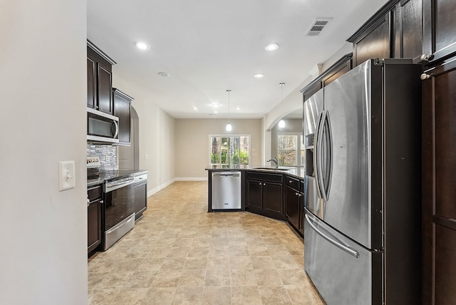 kitchen featuring dark brown cabinetry, stainless steel appliances, sink, and hanging light fixtures