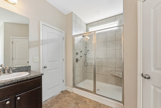 bathroom featuring a shower with door and vanity