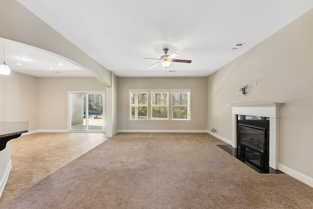 unfurnished living room featuring carpet flooring and ceiling fan