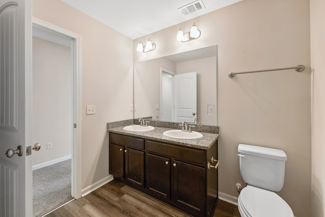 bathroom with hardwood / wood-style flooring, vanity, and toilet