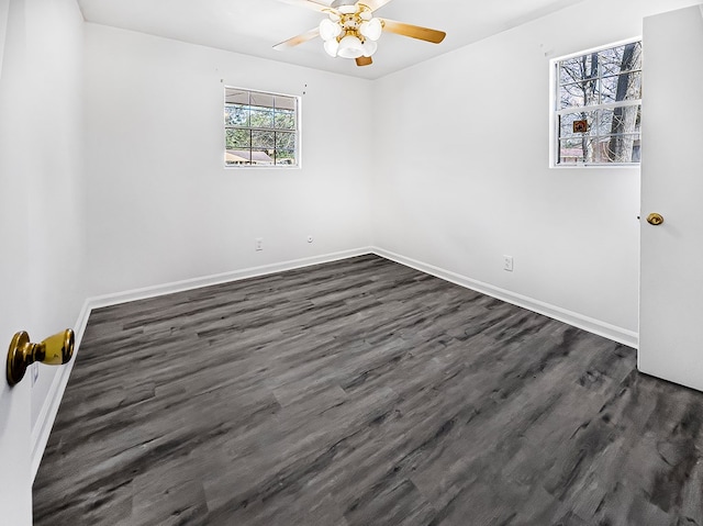 empty room featuring dark wood-type flooring, baseboards, and a ceiling fan