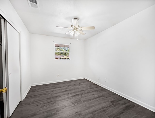 unfurnished bedroom with dark wood-style flooring, visible vents, and baseboards