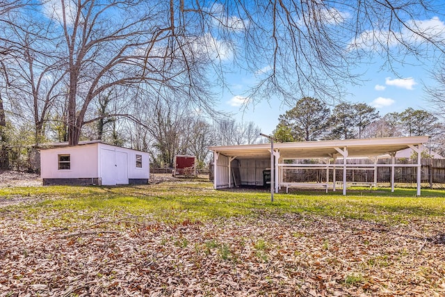 view of yard featuring a carport, an outdoor structure, and fence