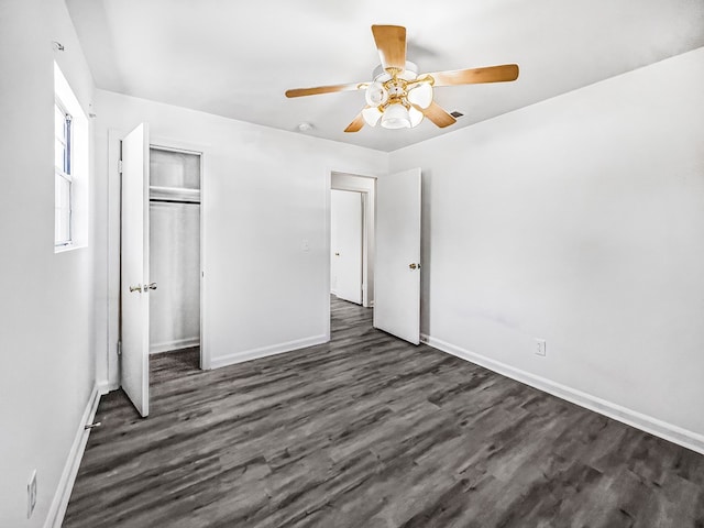 unfurnished bedroom with ceiling fan, baseboards, dark wood finished floors, and a closet